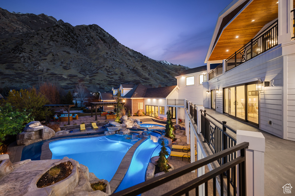 Outdoor pool featuring a mountain view, a patio, and an in ground hot tub