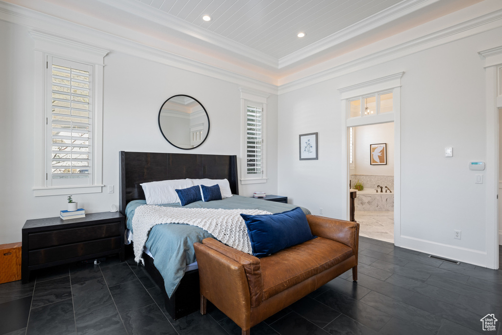 Bedroom with ensuite bathroom, a raised ceiling, ornamental molding, visible vents, and recessed lighting