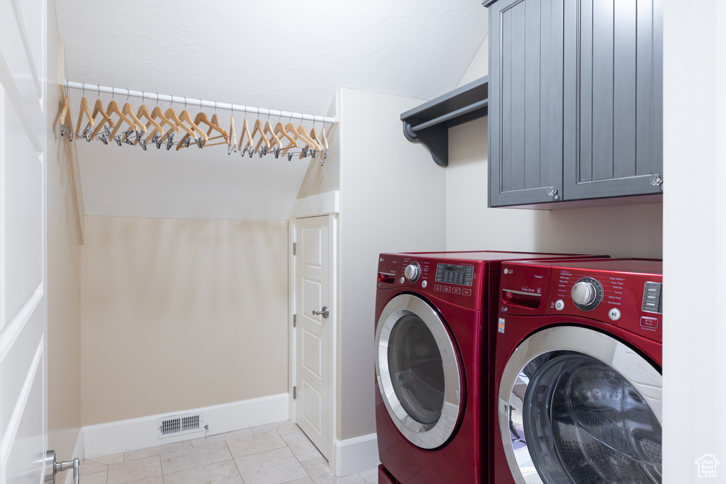 Laundry area with separate washer and dryer, baseboards, cabinet space, and visible vents