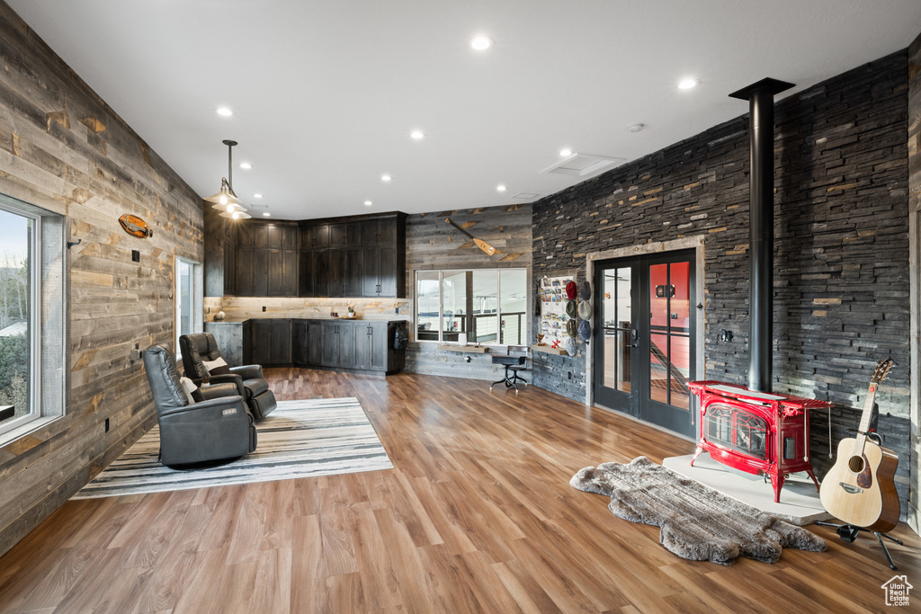 Living room with wood walls, a wood stove, and wood finished floors