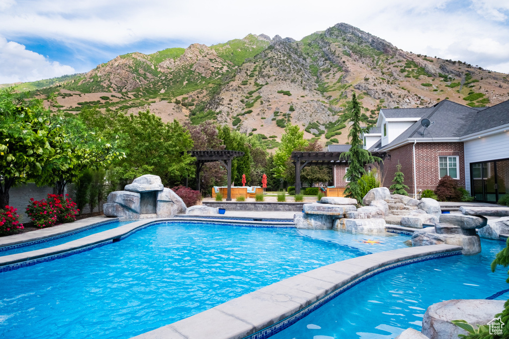 Outdoor pool with a pergola, a mountain view, and a patio