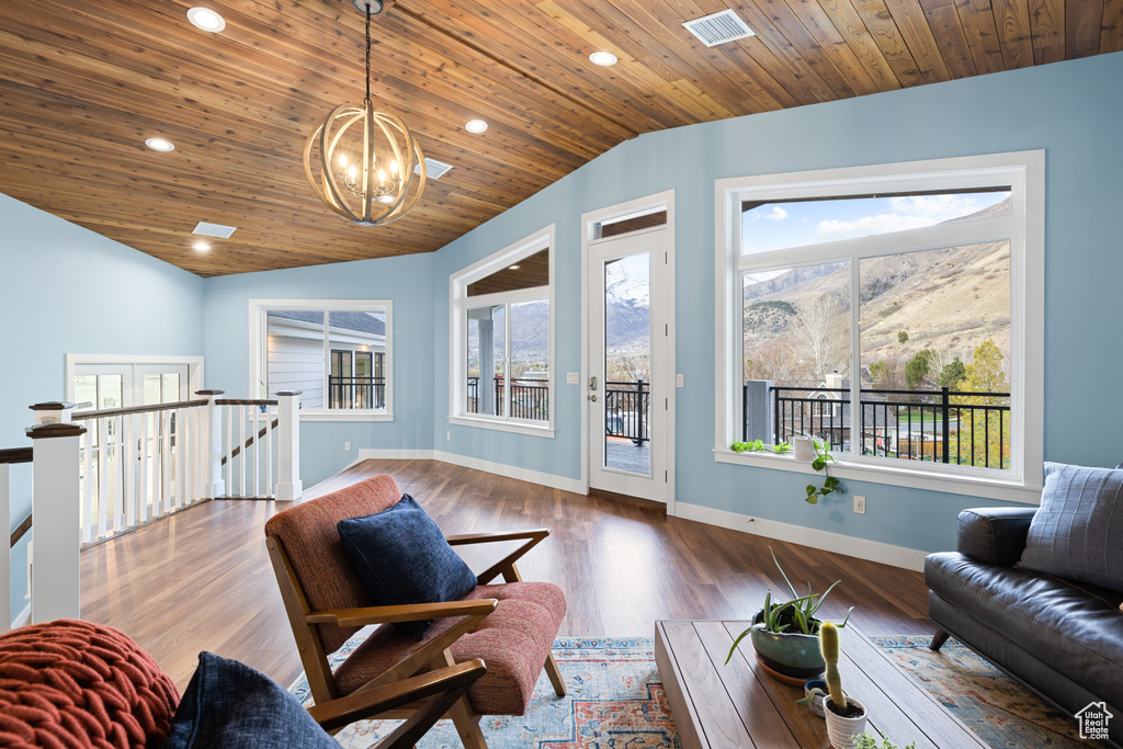 Living room featuring vaulted ceiling, a healthy amount of sunlight, visible vents, and an inviting chandelier