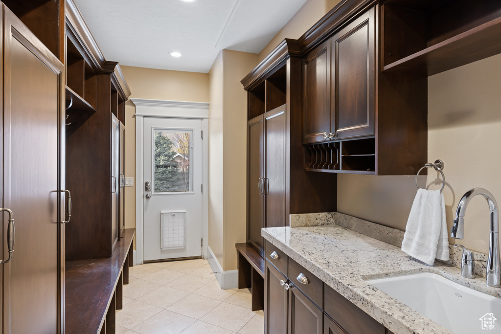 Interior space featuring baseboards, a sink, recessed lighting, and light tile patterned flooring