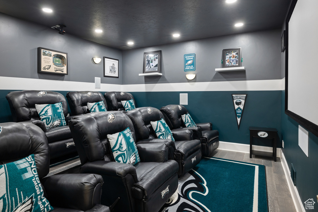 Home theater room with baseboards, wood finished floors, and recessed lighting
