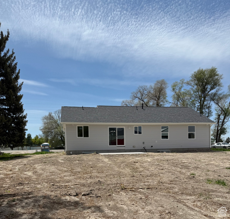 Back of property featuring a shingled roof