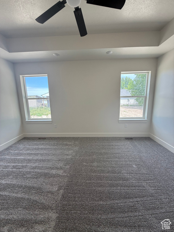 Carpeted empty room with baseboards, a textured ceiling, and ceiling fan