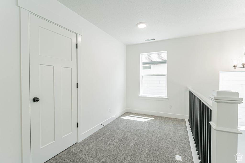 Carpeted spare room featuring baseboards