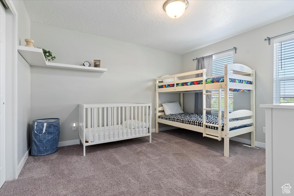 Carpeted bedroom with baseboards and a textured ceiling