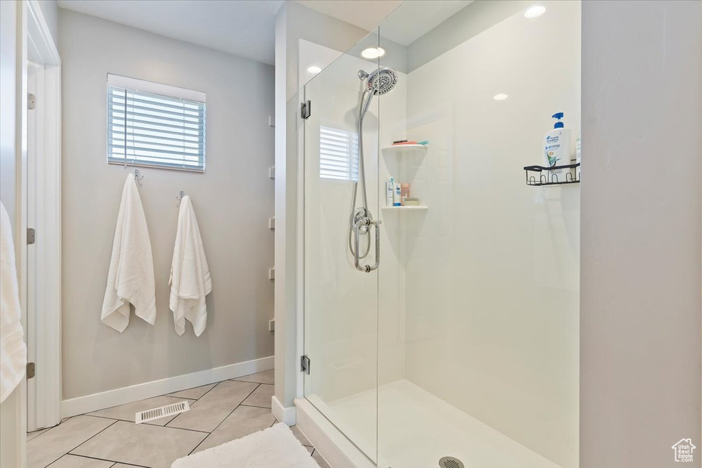 Full bathroom featuring a shower stall, visible vents, tile patterned floors, and baseboards