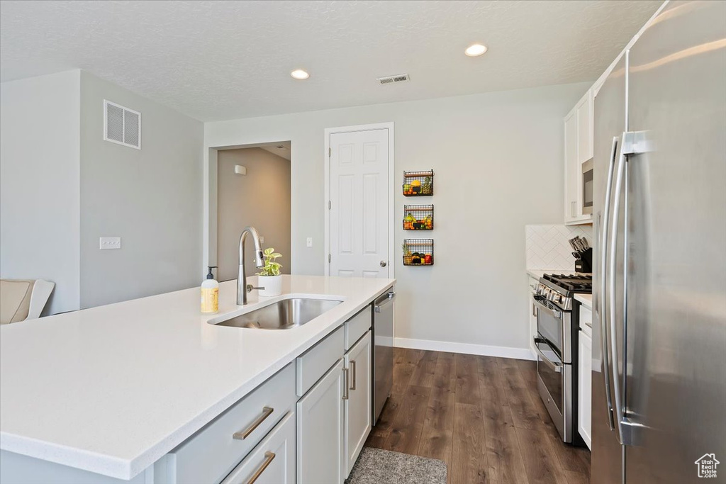 Kitchen featuring visible vents, a sink, appliances with stainless steel finishes, and dark wood-style flooring