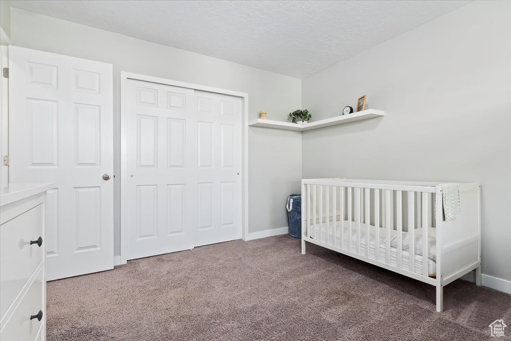 Bedroom with baseboards, carpet flooring, and a closet