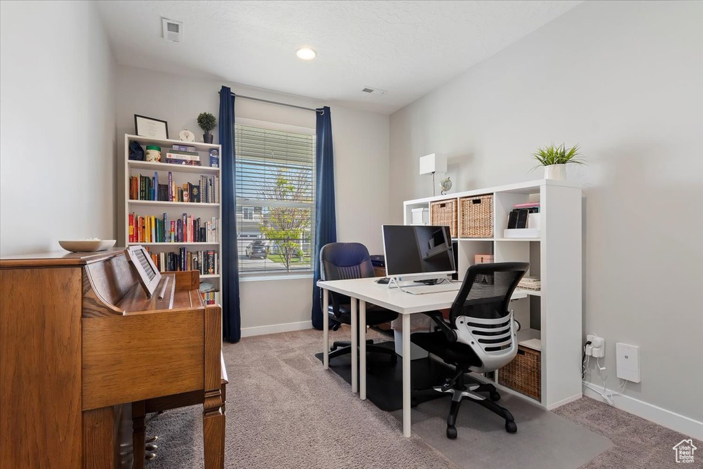 Office space featuring light colored carpet, baseboards, and visible vents