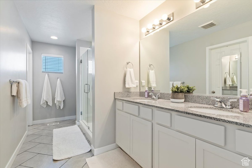 Full bathroom featuring baseboards, a sink, visible vents, and a stall shower