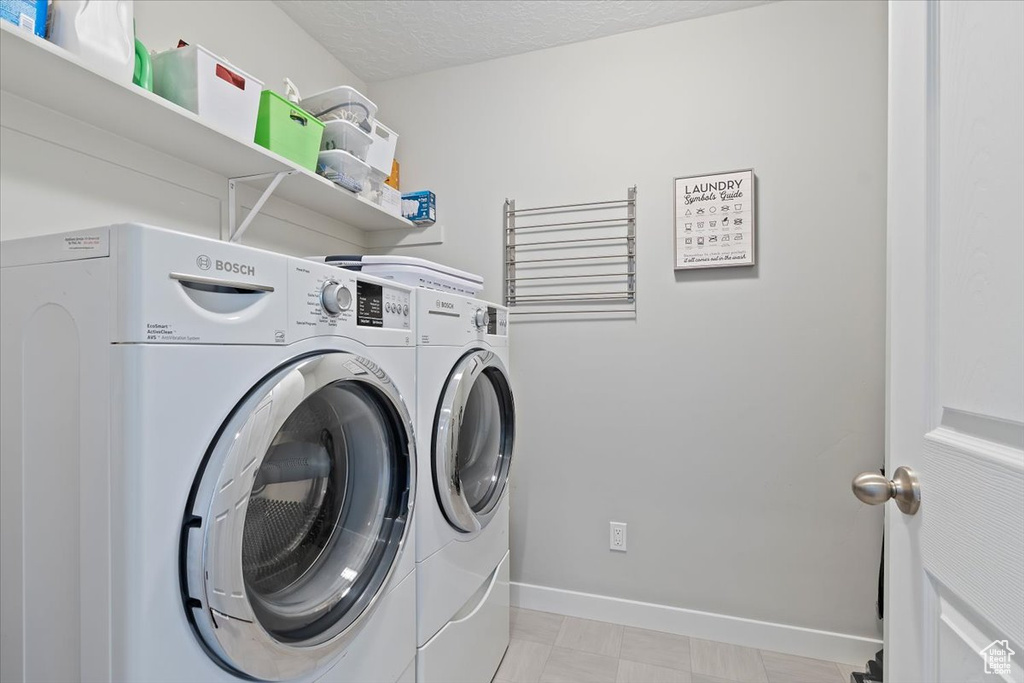 Washroom with separate washer and dryer, baseboards, and laundry area