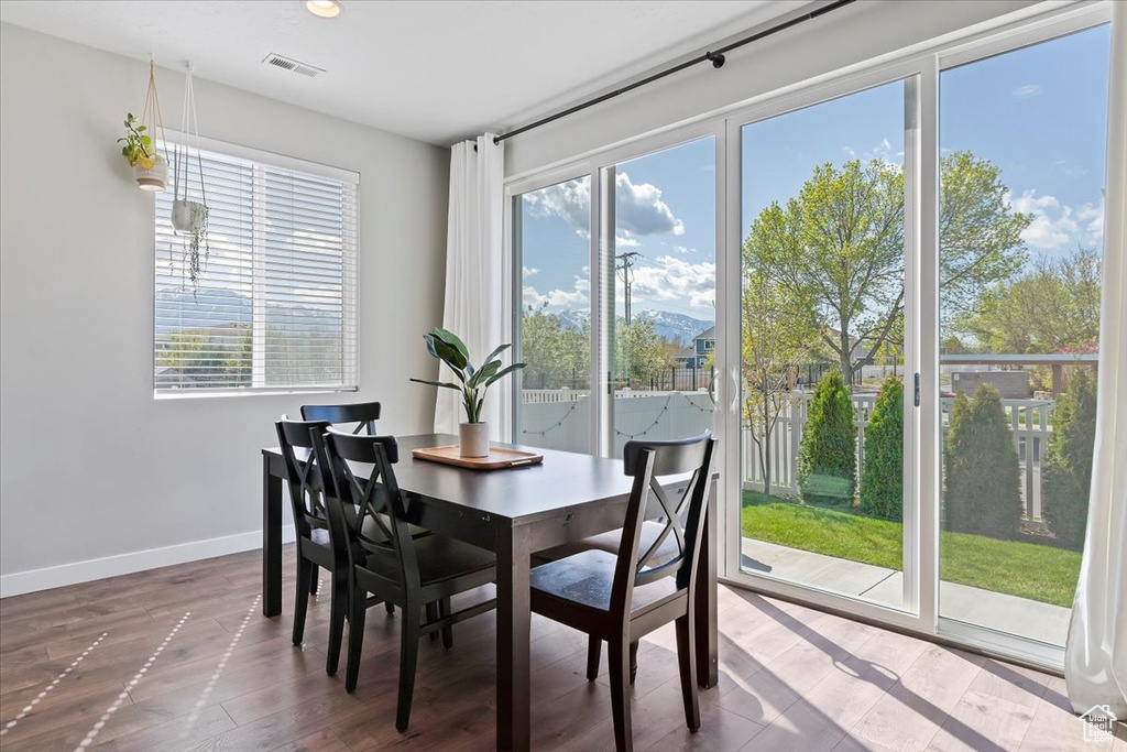 Dining room with baseboards, wood finished floors, and visible vents