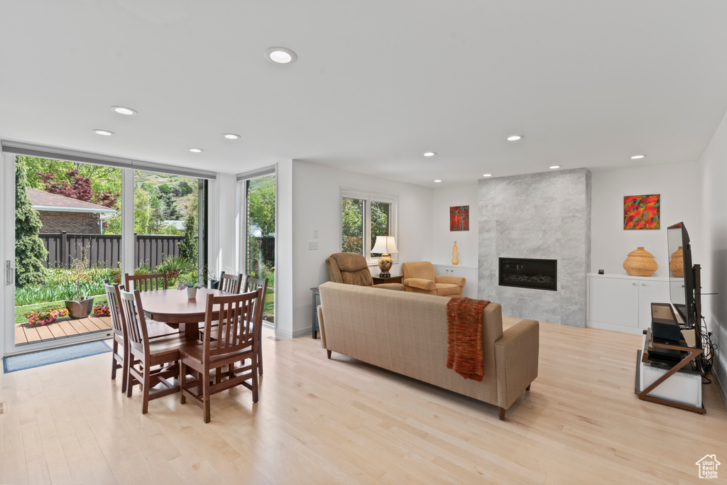 Living area featuring a premium fireplace, recessed lighting, and light wood-style flooring