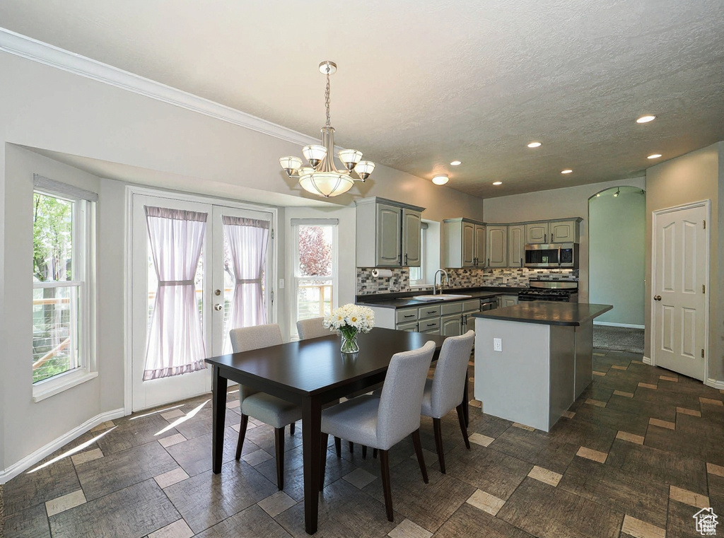 Dining space with a chandelier, recessed lighting, arched walkways, crown molding, and a textured ceiling