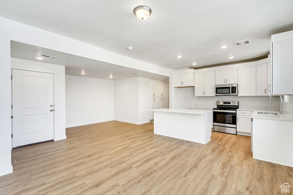 Kitchen with recessed lighting, visible vents, a sink, light wood-type flooring, and appliances with stainless steel finishes