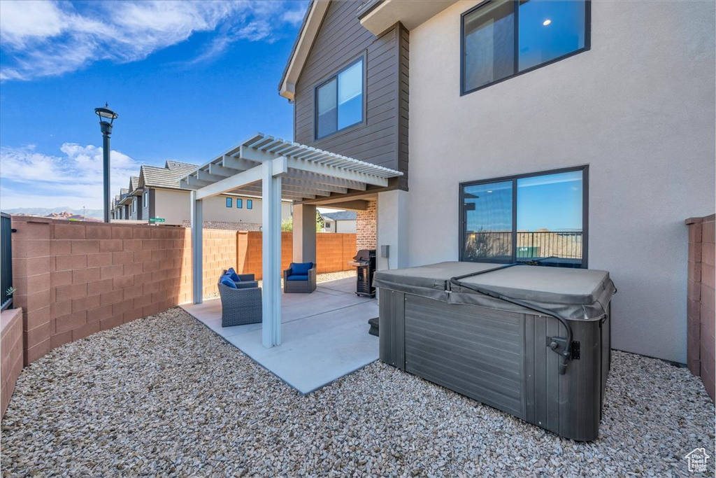 View of patio with a pergola, a fenced backyard, and a hot tub