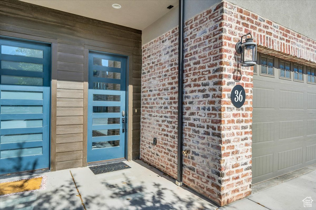 Property entrance with a garage and brick siding
