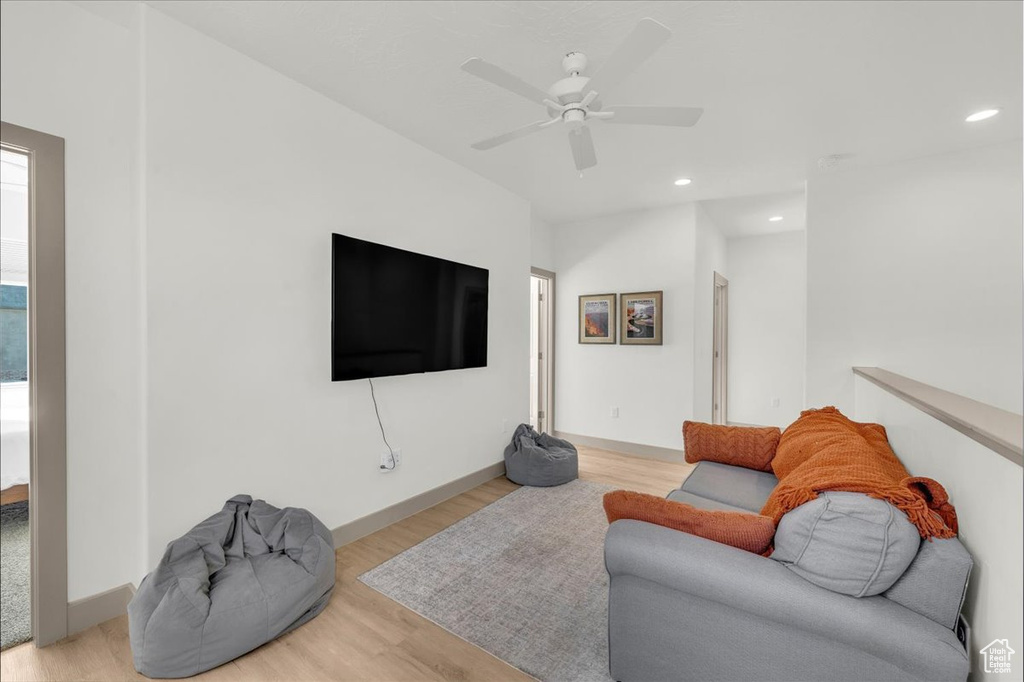 Living room with baseboards, recessed lighting, wood finished floors, and a ceiling fan