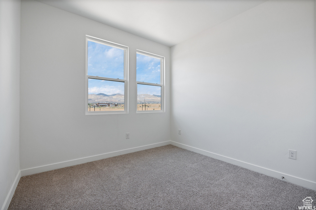 Carpeted empty room featuring baseboards