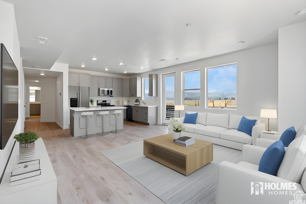 Living room featuring baseboards, light wood-style floors, and recessed lighting