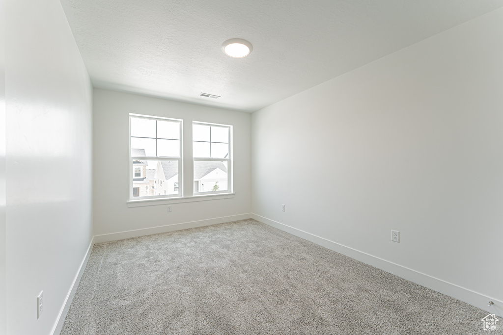 Unfurnished room featuring carpet and baseboards
