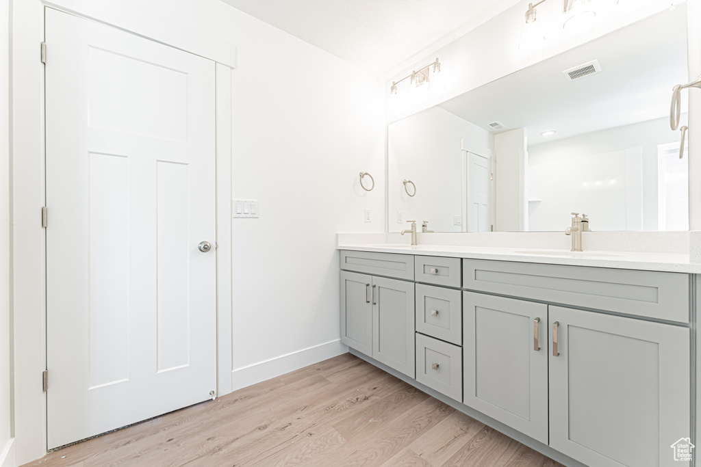 Full bathroom featuring double vanity and wood finished floors