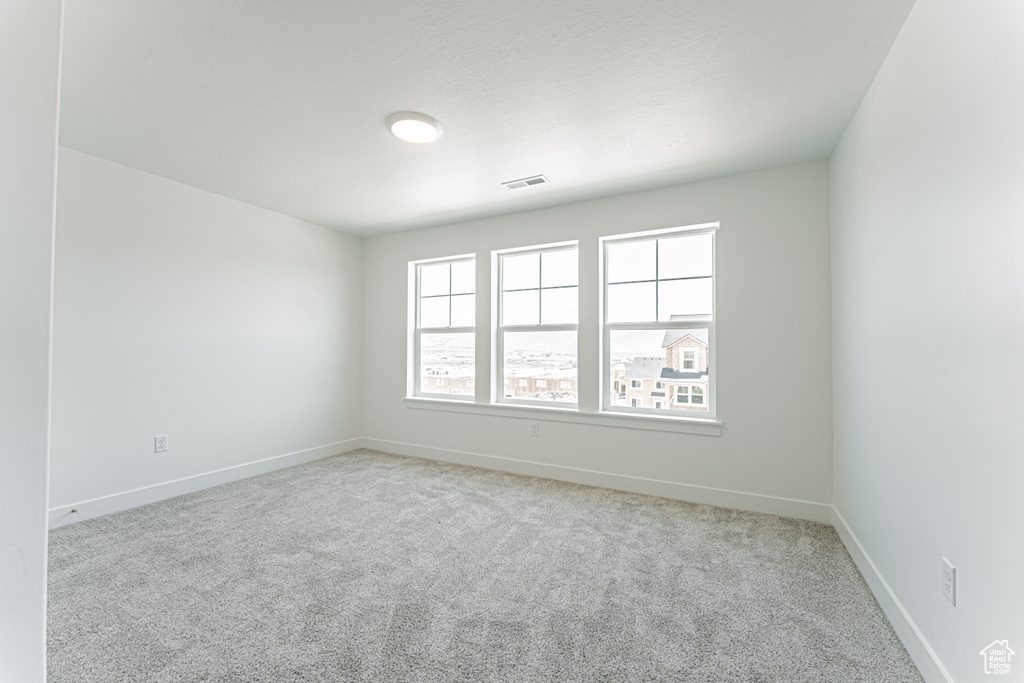 Spare room featuring carpet and baseboards