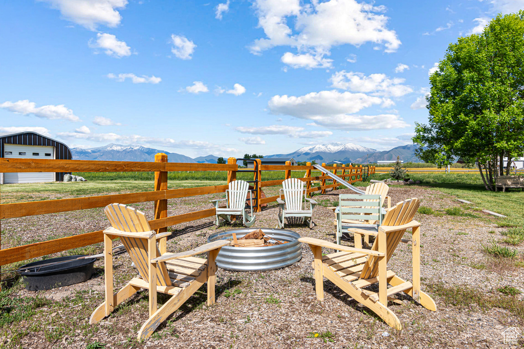 View of yard featuring an outdoor fire pit, a mountain view, and a garage