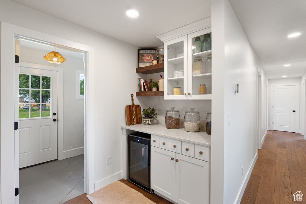 Kitchen featuring beverage cooler, baseboards, recessed lighting, white cabinets, and open shelves