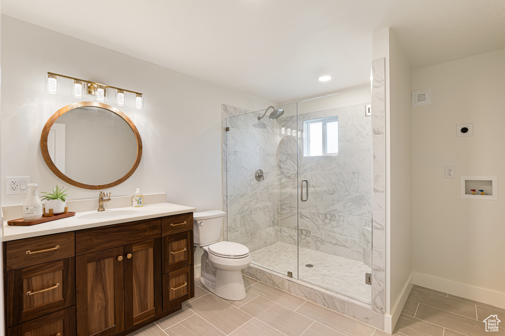 Bathroom with toilet, a stall shower, vanity, baseboards, and recessed lighting