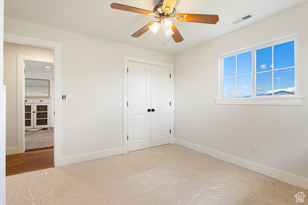 Unfurnished bedroom with baseboards, a closet, and a ceiling fan