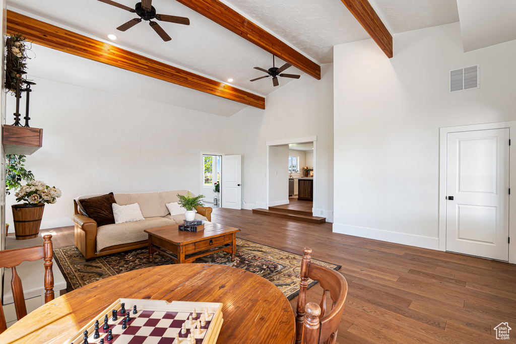 Living area featuring ceiling fan, beam ceiling, wood finished floors, recessed lighting, and a towering ceiling