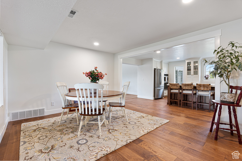 Dining space with wood finished floors, baseboards, and recessed lighting
