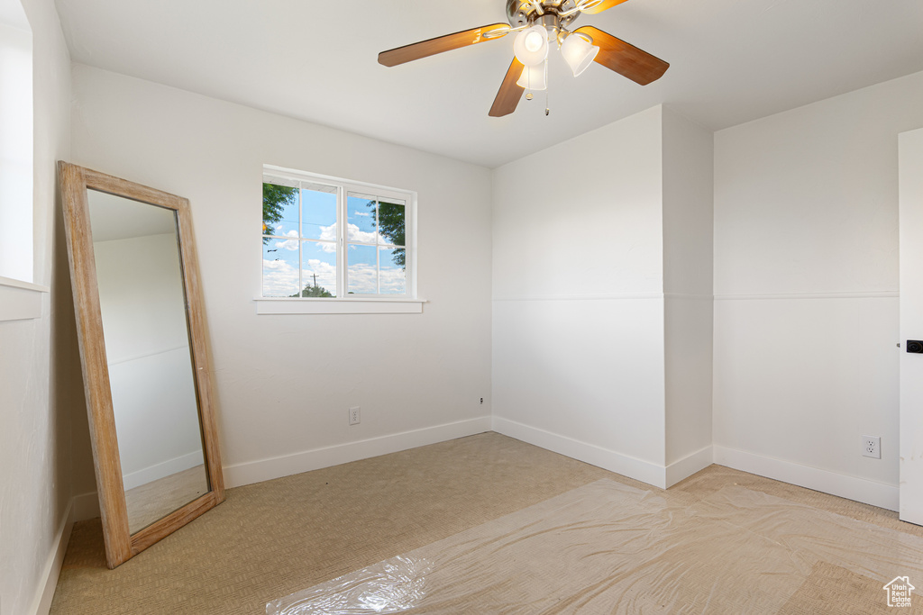 Unfurnished bedroom featuring carpet flooring, baseboards, and a ceiling fan