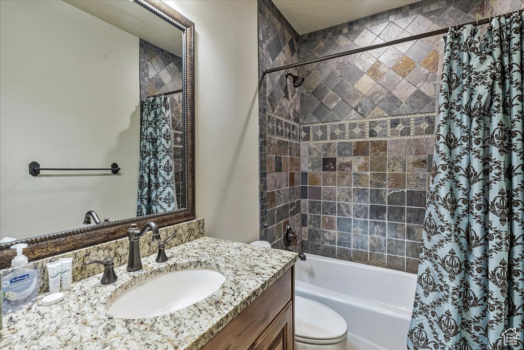 Bathroom with toilet, vanity, and shower / tub combo