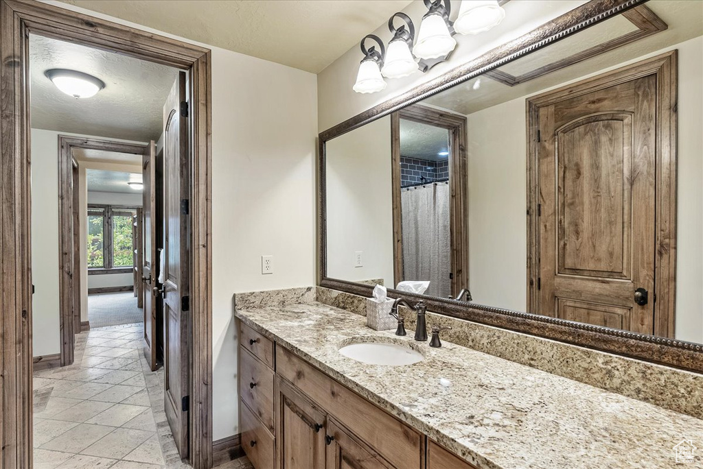 Bathroom with baseboards, vanity, and tile patterned flooring