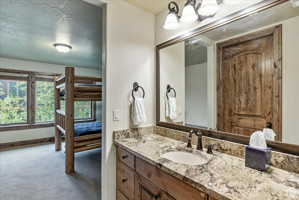 Bathroom with vanity, baseboards, and a chandelier