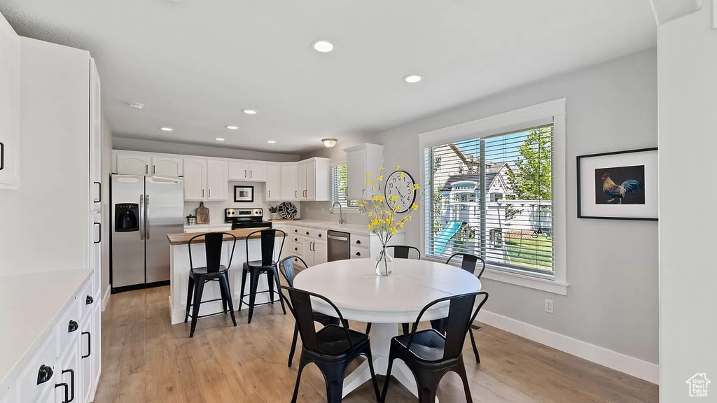 Dining area with baseboards, light wood finished floors, and recessed lighting