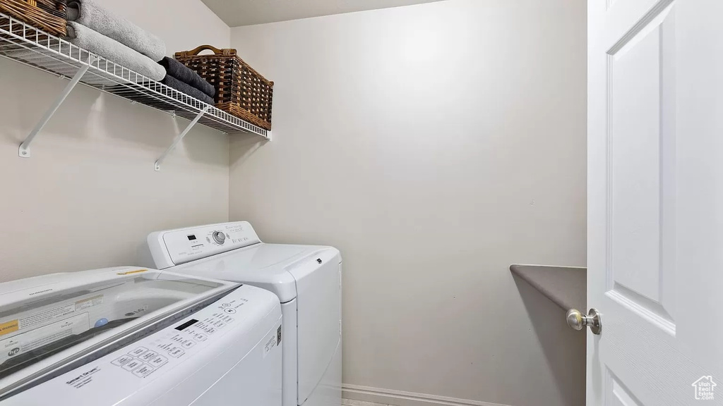 Washroom with separate washer and dryer, baseboards, and laundry area