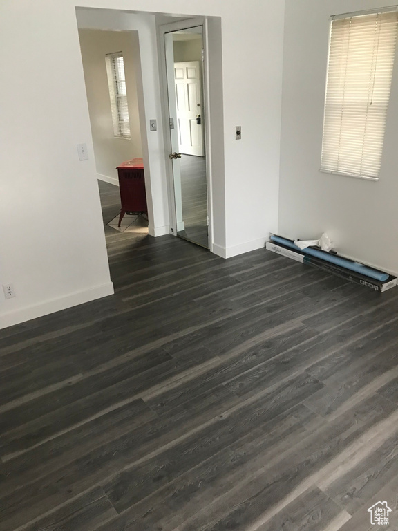 Unfurnished room with baseboards and dark wood finished floors