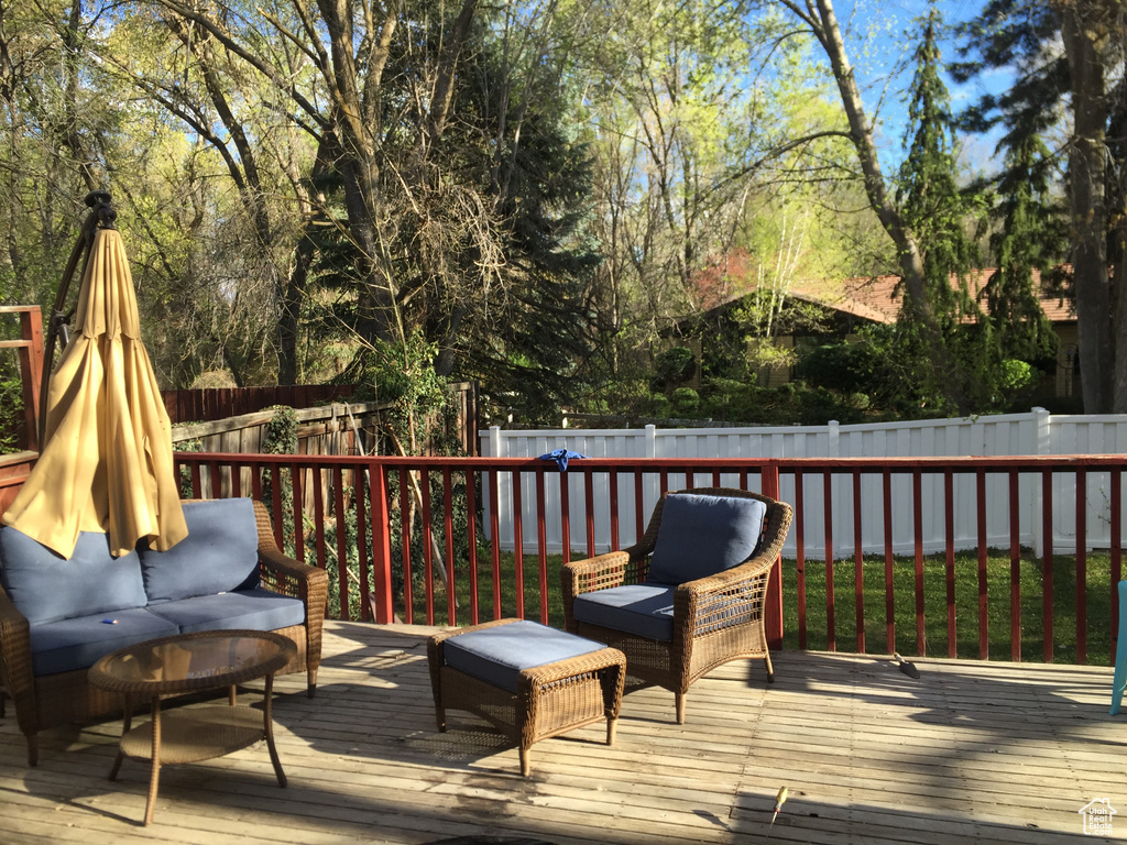 Wooden terrace featuring an outdoor hangout area and a fenced backyard