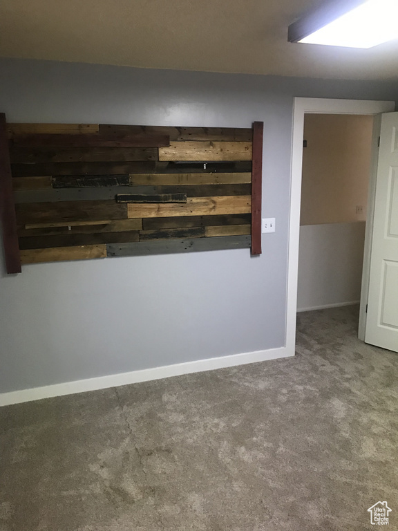 Carpeted spare room featuring baseboards
