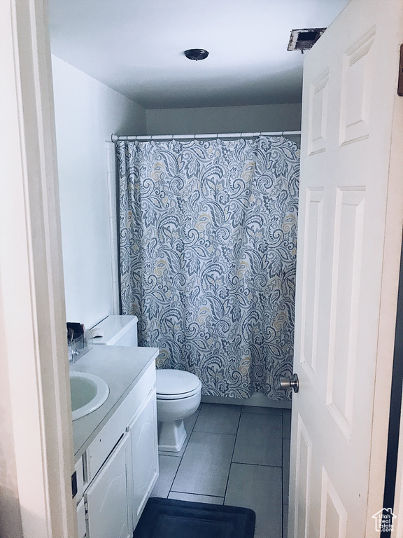 Full bath with tile patterned flooring, toilet, a shower with curtain, and vanity