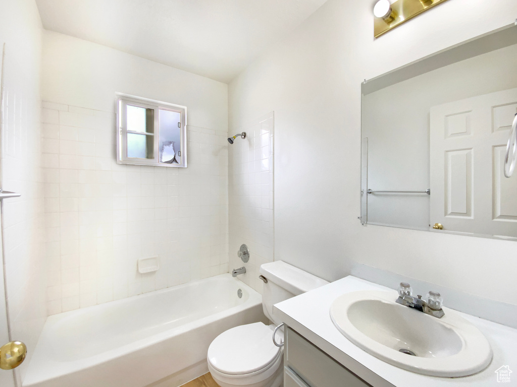 Full bath featuring toilet, vanity, and shower / washtub combination