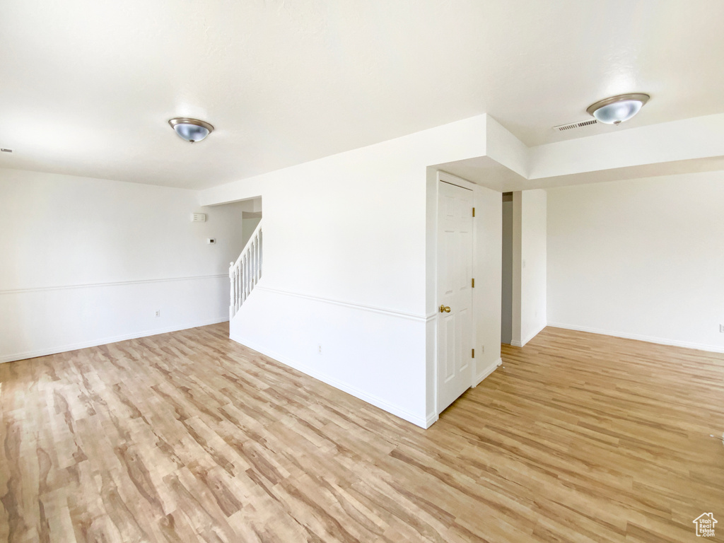 Unfurnished room with light wood finished floors, baseboards, and visible vents