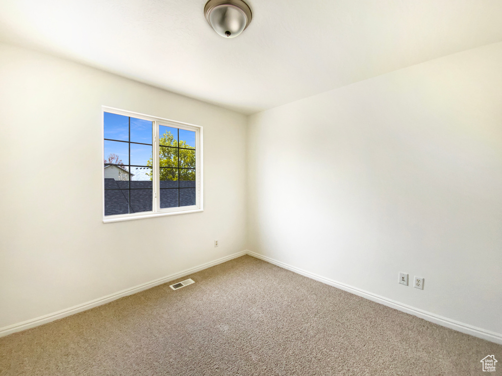 Empty room with baseboards, carpet flooring, and visible vents