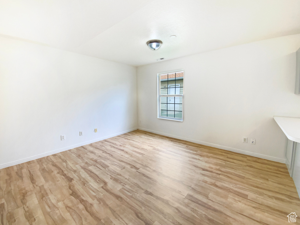 Empty room with light wood-type flooring and baseboards